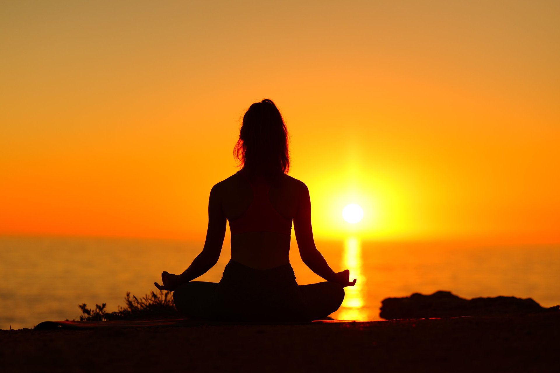 Silhouette of a woman doing yoga with sunset sun — Private Yoga Los Cabos