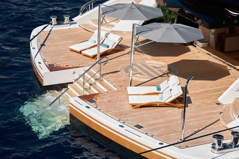Close-up view of a relaxation area on the open teak deck on the stern of an expensive huge mega yacht — yacht wellness experiences