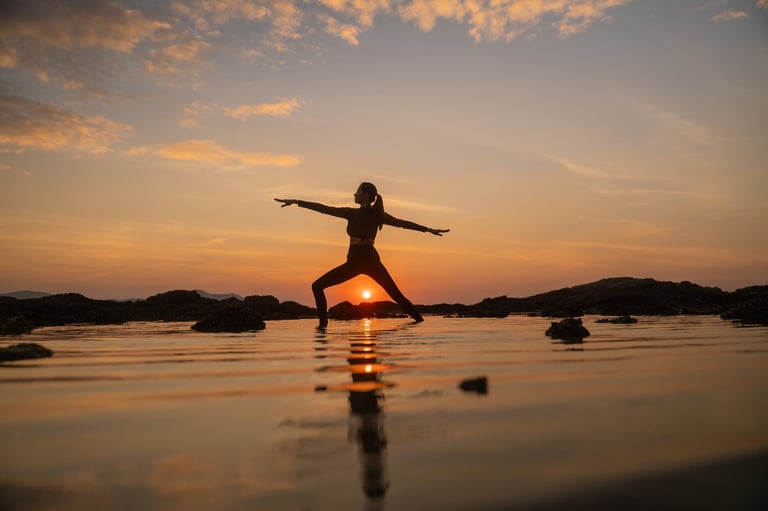 Silhouette of sport woman striking a graceful yoga pose against the glowing sunset — wellness in Los Cabos