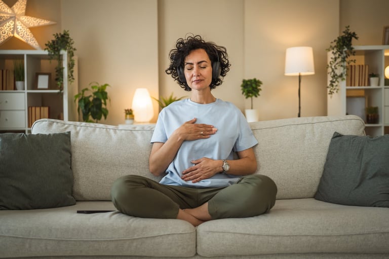 Mujer meditando con audífonos en casa, práctica guiada