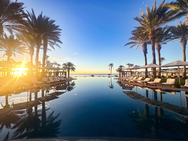 Reflective sunrise over infinity pool in Cabo