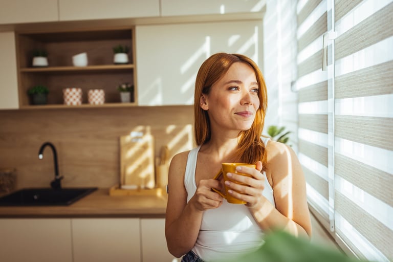Mujer en cocina moderna con luz de mañana — presencia, calma y claridad