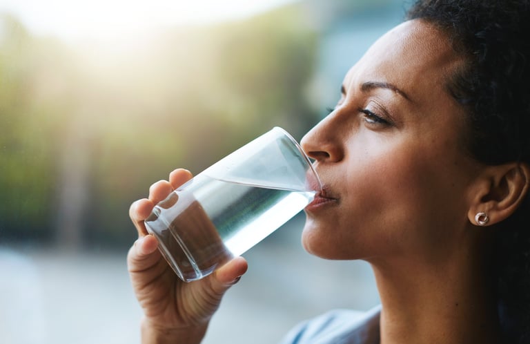 Mujer bebiendo agua, sintiéndose fresca y saludable